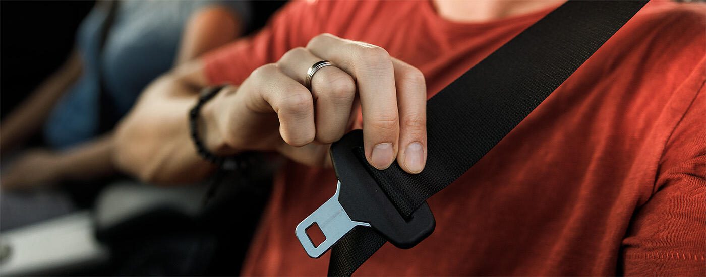 Passenger applying seatbelt